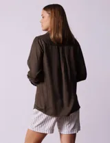 Camisa color verde oliva de lyocell, marca Cyrus. Tiene cuello con solapa, abertura central con botones, mangas 3/4 regulables con presilla y botón, y dos bolsillos delanteros aplicados.