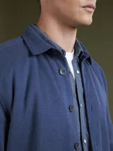Campera tipo sobrecamisa color azul piedra, con cuello clásico, cierre frontal con botones y textura de tejido de punto.