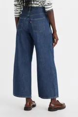 Pantalón de jean azul oscuro, corte ancho, tiro medio y bolsillos laterales.