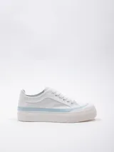 Zapatilla de lona blanca con cordones, puntera de goma y plataforma de 3 cm. Detalle de pespuntes celestes en la suela.