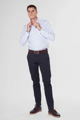 Pantalón de gabardina color marrón claro, corte slim fit, con bolsillos laterales y traseros. Se ajusta a la cintura con cinturón de cuero marrón.