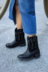 Bota tejana de cuero negro con bordado de cactus en hilo blanco.