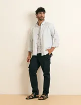 Pantalón cargo color verde militar, de corte recto, con bolsillos laterales con fuelle, bolsillos delanteros inclinados y bolsillos traseros.