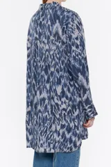 Camisa larga de viscosa con estampado de cebra en blanco y negro. Modelo de corte recto, cuello camisero, manga larga, puño con botones y cierre frontal de botonadura.