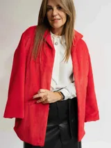 Tapado negro de piel sintética con cuello solapa y mangas largas. El forro interior de las mangas tiene un estampado animal print.