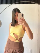 Body amarillo de un hombro con abertura en la cintura y aro metálico.