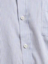 Camisa de manga larga con patrón de rayas verticales celestes y blancas, corte regular fit, cuello con botones y un bolsillo en el pecho con logo bordado.