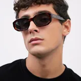 Lentes de sol unisex con armazón geométrico carey y lentes polarizadas negras.