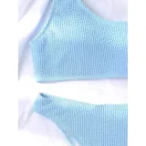 Conjunto de bikini texturado color tostado, compuesto por un top de un solo hombro y bombacha vedetina tiro medio.