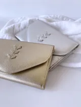 Billetera plateada de cuero con cierre de broche y monedero externo.