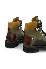 Borcego de cuero verde con detalles en marrón y negro, con cordones y suela track.
