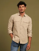 Camisa de manga larga color azul con dos bolsillos frontales con botón.