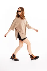 Botas acordonadas de cuero color camel, con elásticos laterales negros, suela track color negro y tirador trasero color rojo.