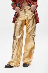 Pantalón de cuero estilo western con efecto desgastado y costuras decorativas en los bolsillos delanteros. Presenta un corte recto y holgado con costuras horizontales a la altura de la rodilla.