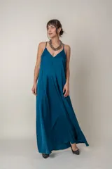Vestido largo de seda en color azul petróleo, con escote en V, breteles finos y bolsillos laterales. Diseño holgado y fluido.
