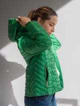 Campera acolchada color fucsia, con cierre frontal y capucha. Presenta un diseño capitoneado con costuras onduladas.