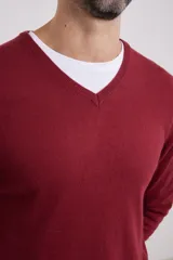 Suéter de punto color azul marino con cuello en V y manga larga. Se lleva sobre una remera blanca con cuello en V.