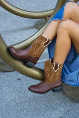 Botas tejanas de cuero vacuno color marrón con apliques de gamuza color camel y bordados en hilo blanco.