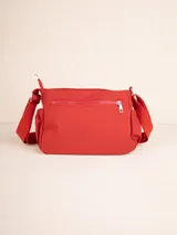 Bandolera color marrón claro de nylon con correa regulable, tres compartimentos, un bolsillo interno y dos bolsillos laterales con elástico.