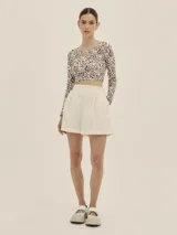 Shorts celestes a rayas verticales, de tiro alto y corte holgado, con pinzas en el frente y detalle de Polonio en cobre.