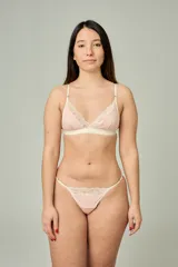 Conjunto de lencería de algodón color rosado, compuesto por un bralette triangular con detalles de encaje crudo en las copas y una tanga a juego con tiras regulables y detalles de encaje.