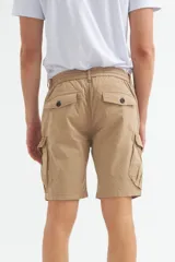 Bermuda cargo color gris oscuro, confeccionada en gabardina con efecto teñido. Presenta pretina elástica con cordón de ajuste, bolsillos laterales y bolsillos cargo con solapa en las piernas.