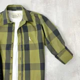 Camisa de manga 3/4 con cuello italiano y estampado a cuadros verde oliva y negro.