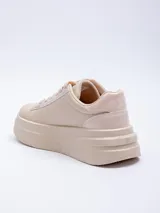 Zapatillas acordonadas color marrón con base de plataforma blanca y recortes texturizados.