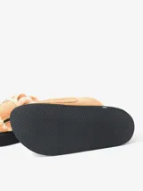 Zueco negro de cuero con plataforma y plantilla recubierta de piel de oveja. Presenta una hebilla dorada de gran tamaño en la capellada.