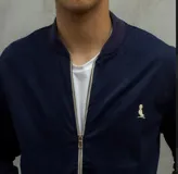 Campera bomber azul marino de gabardina con cierre frontal y logo bordado en el pecho.