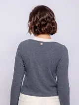 Top marrón de punto, manga larga y escote en V con cierre de dos botones. Incluye una remera blanca de cuello alto debajo.