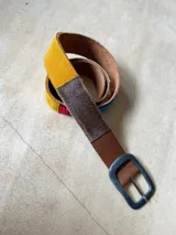 Cinturón de cuero marrón con apliques de tela aguayo de colores y hebilla metálica plateada.