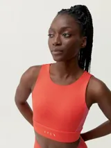 Top deportivo bicolor con diseño sobrio y elegante de sujeción alta. Tejido Shapplex_B. Escote redondo, en la espalda combina tirantes de diferente ancho y color.