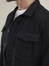 Campera tipo overshirt color azul marino, con cuello clásico, cierre frontal con botones, cuatro bolsillos frontales con solapa y puños abotonados.