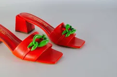 Sandalias tipo sueco color amarillo, con taco ancho y aplique de cadena en el empeine.