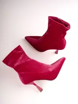 Bota tipo botín de terciopelo color fucsia, con punta fina y taco acampanado de altura media.