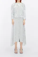 Falda midi color gris plata de terciopelo con textura, cierre frontal con botones y lazo en la cintura.