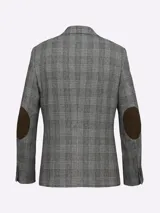 Saco de paño marrón con diseño a cuadros en tonos marrón, rojo y blanco. Tiene cuello con solapas, bolsillos de plastrón en pecho y cadera, mangas con coderas en contraste de color, forro estampado y aberturas en espalda.