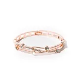 Brazalete rígido dorado con diseño calado y detalles de strass.