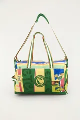 Bolso tote deportivo tipo duffel, multicolor con diseño estampado de rayas y parches estilo club deportivo, con asas de mano y correa ajustable para el hombro.