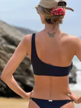 Top de bikini de lycra celeste con un solo hombro y argolla de madera decorativa.