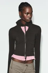 Sudadera cropped de punto con cierre frontal de cremallera metálica, capucha ajustable con cordones y mangas largas con puños en rib.