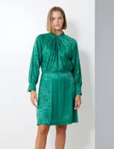 Vestido corto color borgoña con estampado geométrico, de gasa laminada con cuello alto entrelazado, manga larga raglán, cintura elastizada y espalda con abertura ojal y botones.