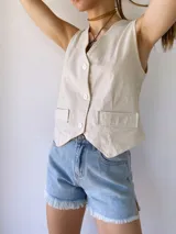 Colgante con cordón de cuero color camel y dije metálico dorado con forma de estribo.