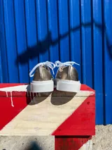 Championes de cuero color peltre con cordones blancos y suela blanca.