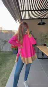 Sweater de punto fucsia con cuello redondo y corte asimétrico con aberturas laterales. Detalle de rib en color beige en cuello, puños y ruedo.