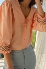 Blusa color salmón con cuello XL, mangas abullonadas y bordado elastizado en los puños.