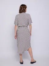 Vestido camisero midi azul con estampado floral blanco, corte recto, cuello camisero, mangas cortas, bolsillos laterales y lazo ajustable en la cintura.