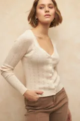 Cárdigan corto color verde agua, de tejido tramado y corte ajustado.