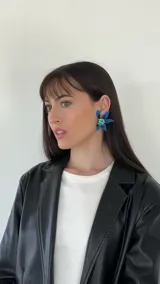 Aros colgantes con forma de flor, con pétalos azules y centro con strass verde.